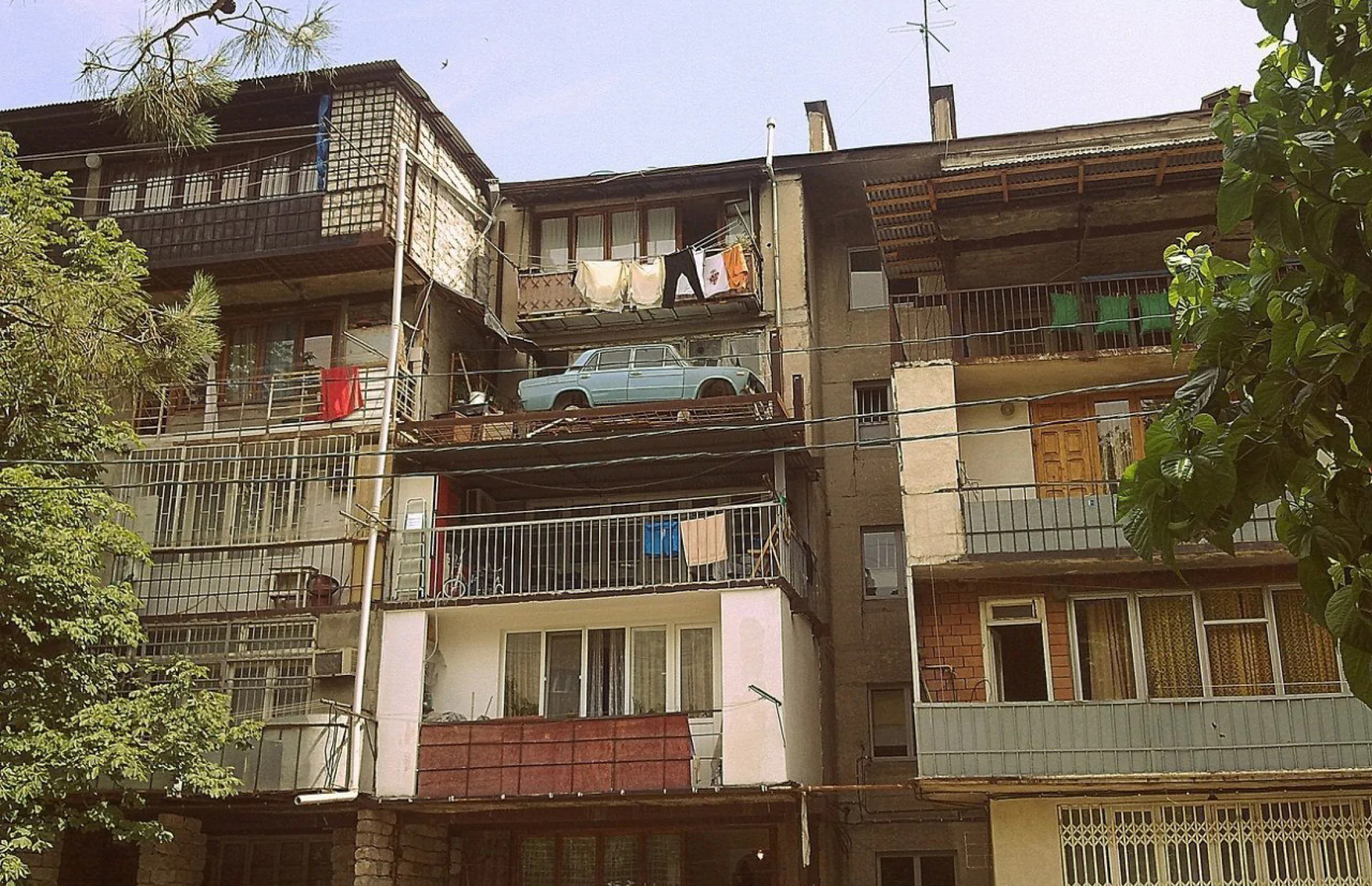 Auto in einer Garage auf dem Balkon eines Wohnhauses in Tiflis vor 30 Jahren