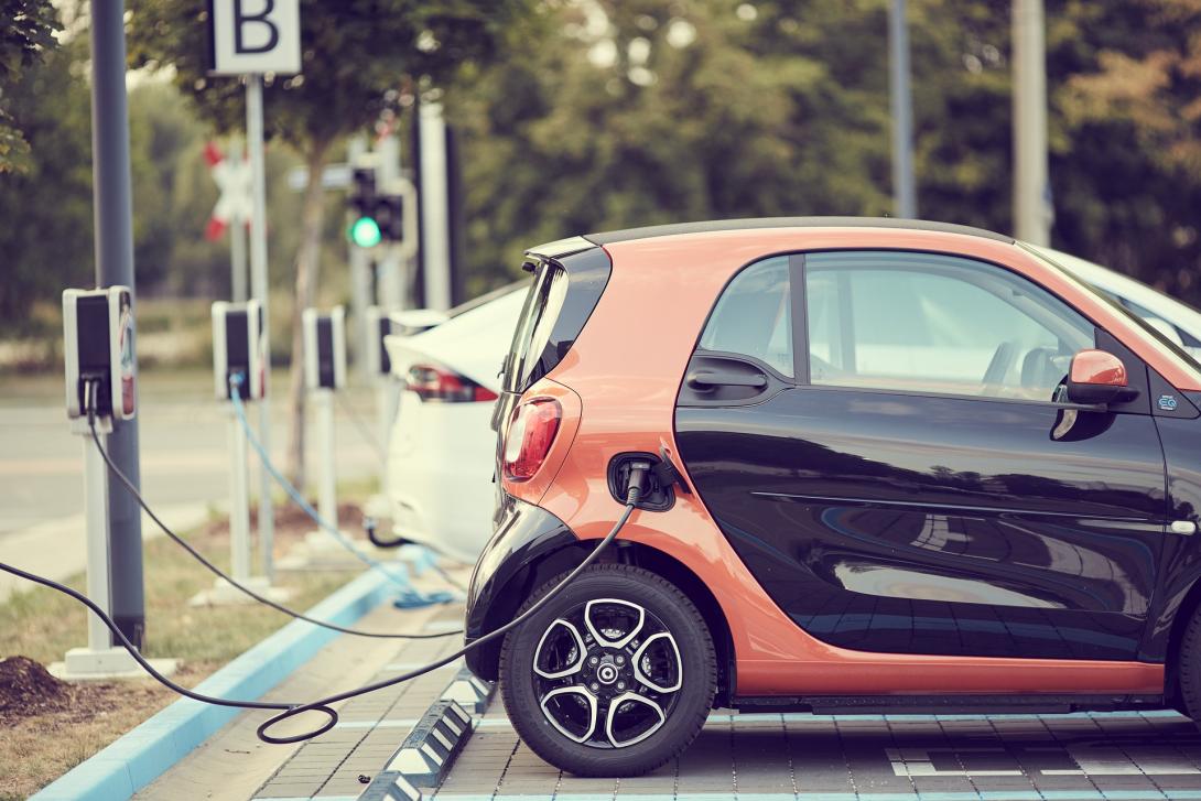 Ein Elektroauto steht auf dem Parkplatz für Elektroautos und wird aufgeladen.